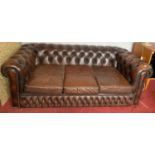 A brown leather button back sofa. 180 w x 89 d x 66cms h.Condition ReportMoth damage to lining. Some