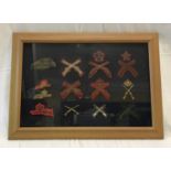 A framed and mounted early 20th century military marksman crossed rifles patches and badges,frame