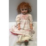 A German Simon and Halbig pot headed doll with a composite body, open/close eyes and moveable