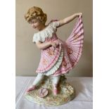 A continental figurine of a young girl in a pink dress and ballet shoes with a tambourine. 40cms h