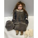 A German pot headed doll with a leather body, open/close blue eyes and pottery hands. Stamped to the