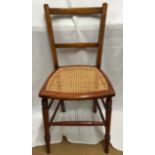 A stained beechwood wicker seated chair. Height to seat 45cm. Height to back 83cm, width 40cm.