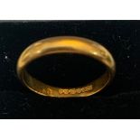 A 22ct gold wedding ring. 3.6gms. Size M. The band is 19mm wide.