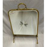 A brass framed fire screen with a bevel edged mirror and star burst design to the centre. To top