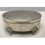 A hallmarked silver oval shaped trinket box on four pad feet with lined interior. Chester 1921.