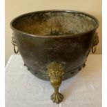 A copper and brass cauldron on lion's paw feet with lion's mask handles. 41cms d x 34cms h.Condition