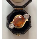 A 18ct gold cross over ring set with two diamonds set either side of a central oval cut Mandarin