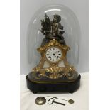 A glass domed decorative mantle clock with cherub mount and enamel face. Clock approx. 33cm h,