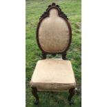 Victorian walnut carved back nursing chair with scroll cabriole legs on brass castors. Height to