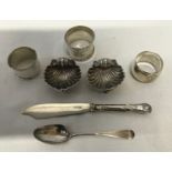 A collection of silver table ware to include a pair of shell shaped salt and pepper dishes 6cm w