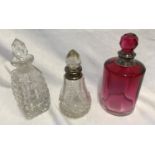 Three glass scent bottles to include one cranberry coloured 12cm h with sterling silver rim, one