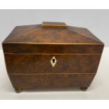 An early 19thC sarcophagus shaped tea caddy in burr yew with ivory escutcheons and ring handles to