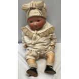 An A.M. Germany pot headed doll with composite body, open/close eyes approx 53cm h. Stamped to the