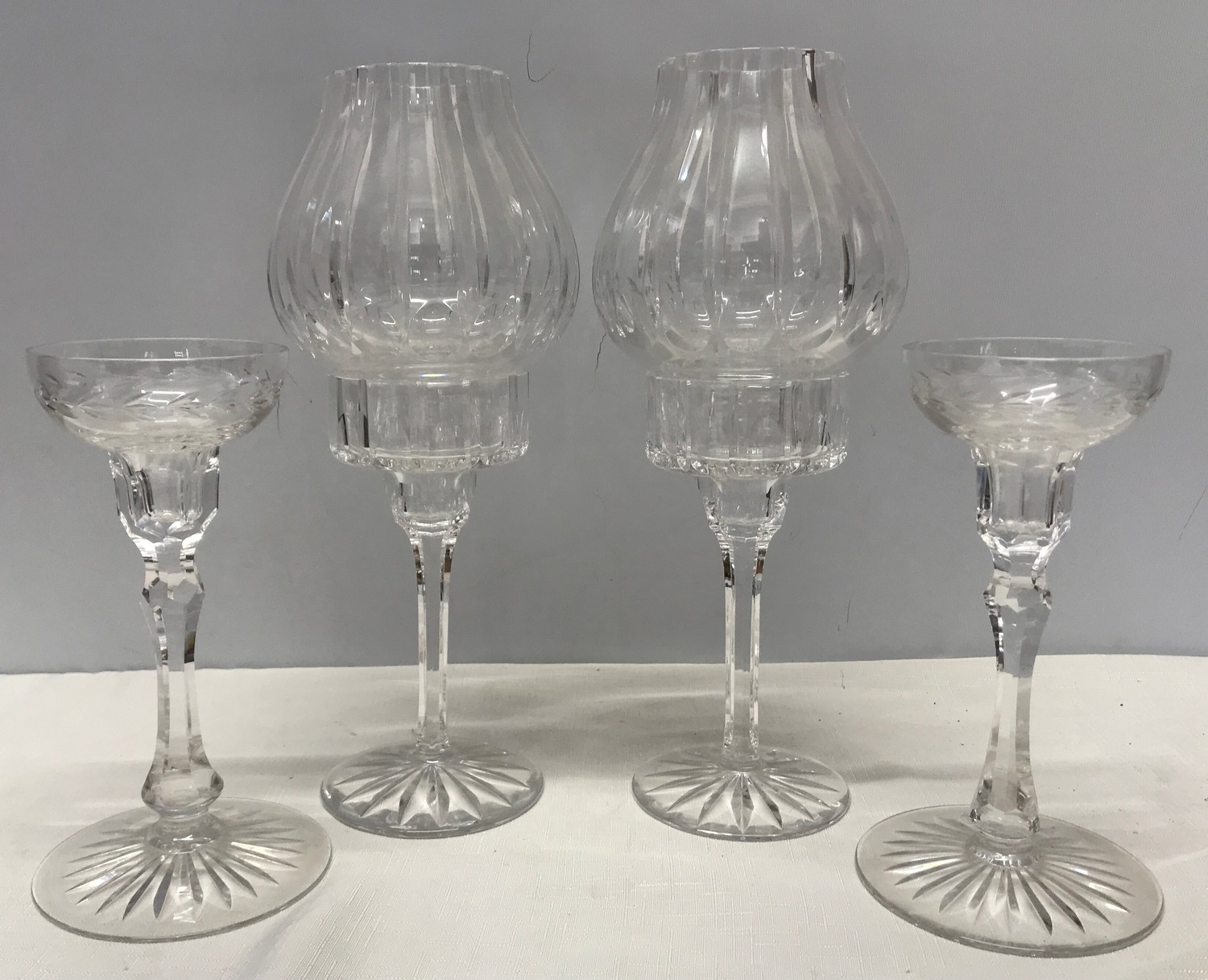 Two pairs of cut glass candlesticks, one pair with shades, 31cms h, small pair 20cms h.Condition