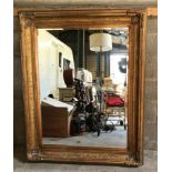 A large gilt framed over mantle mirror with bevel edging. Frame size 122cms x 152cms.Condition