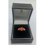 A 9ct gold lady's dress ring set with 3 coral stones, size M.Condition ReportGood condition.