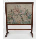 A mahogany framed firescreen with needlework panel cottage garden design. 71cms h x 58cms w.