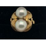 An 18ct gold ring set with two cultured pearls. Size L/M. 6.2gms total weight.Condition ReportGood