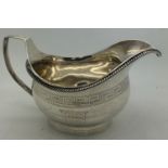 A George III silver jug with engraved frieze of repeating Greek-key motifs and gadrooned border.