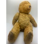 A vintage straw filled teddy 29cms h.Condition ReportLacking eyes and ears. Stitching coming