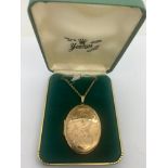 A 9ct gold oval locket on 9ct gold chain, 61cms l, locket 4.5 x 3cms. 14.9gms total weight.