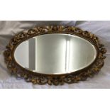 A decorative gilt framed oval bevel edged wall mirror. Frame size 75cms x 47cms.Condition ReportSome