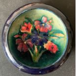 A Moorcroft circular dish, 11.5cms h, blue ground with floral decoration.Condition ReportGood