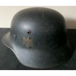 A WWII German helmet with eagle to side and leather liner. Metal interior stamped 4859 and SE64.