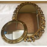 A brass circular convex wall mirror 30cms w and a gilt plastic decorative framed oval wall mirror