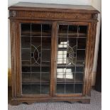 An oak two door display cabinet with leaded glass doors. 113cms h x 92cms w x 33cms d. Cond: Good