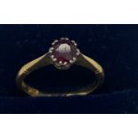An 18ct gold and platinum ring set with a single red stone. Size M. 2.7gms.Condition ReportScratches