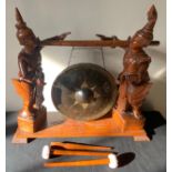 An early 20thC Indonesian gong with carved wooden frame of two figures.Condition ReportFigures a/f