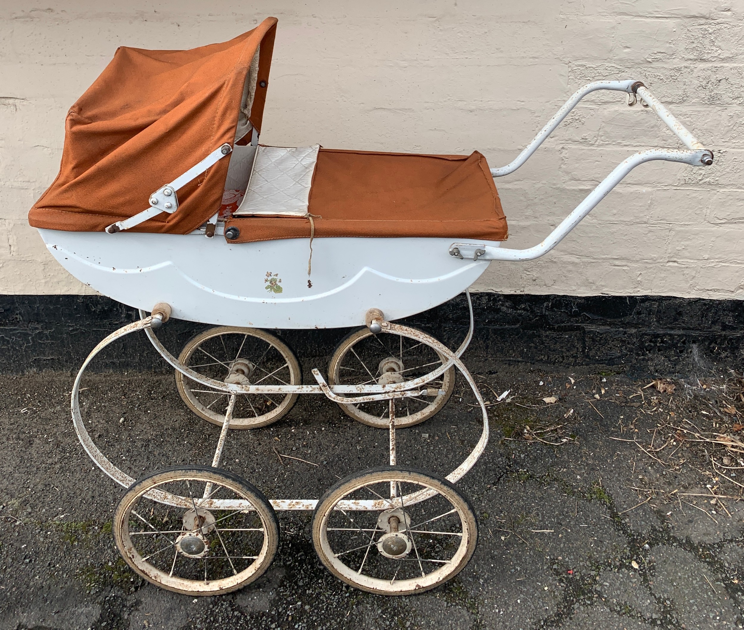 A mid 20thC dolls pram with original cover and hood. 85 l x 85cms h.Condition ReportSome rust to