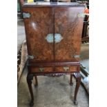 A walnut mirrored back cocktail cabinet with decorative fittings, 2 drawers and cabriole legs. 60cms