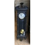 An ebonised wooden cased pendulum wall clock with enamel face and Roma numerals. Height including