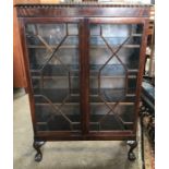 A mahogany 2 door display cabinet with astragal glazed doors , cabriole legs and claw ball feet.