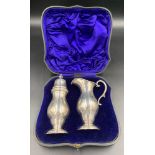 A cased silver sugar shaker and cream jug Birmingham 1905, maker William Aitken. Total weight