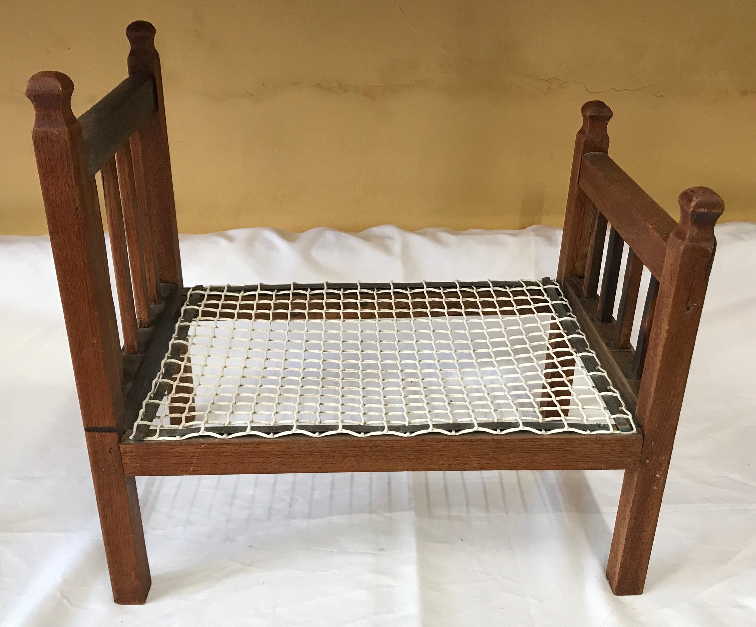 An oak framed dolls bed 50cms L x 32cms w.Condition ReportFairly good condition, no issues.