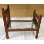 An oak framed dolls bed 50cms L x 32cms w.Condition ReportFairly good condition, no issues.