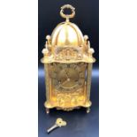 A large decorative lantern clock with key and pendulum. 39cms h to carry handles 18cms w.Condition