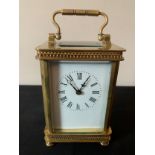 An 8 day carriage clock, cornice case with white enamel face. Height to handle 16cms.Condition