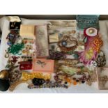 A large quantity of vintage costume jewellery to include necklaces and brooches and a round