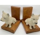 A pair of oak bookends with white Scottie dogs. 10.5cms h.Condition ReportSome paint chips.