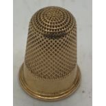 A yellow metal thimble tests as 9ct gold. 6.2gms. 2cms h.