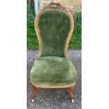 A 19thC upholstered nursing chair on cabriole legs and porcelain casters, buttoning to back.