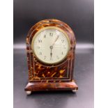A tortoiseshell mantle clock, 20.5cms h, white metal string inlay.Condition ReportLacking inlay to