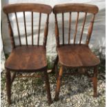 A pair of stick back dining chairs with oak seats and beechwood frames. Height to seat 45cms, to