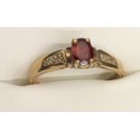 A 9ct garnet and diamond set ring. Size M. 1.9gms.