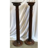 A pair of oak torchere stands with Corinthian columns. 118cms h x 29cms w at base.Condition