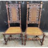 A pair of Carolean style oak chairs.Condition ReportChip to one leg. Overall good.